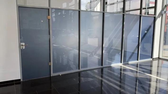 Glaswand mit Tür und grauer Sichtschutzfolie aus einem anderen Blickwinkel